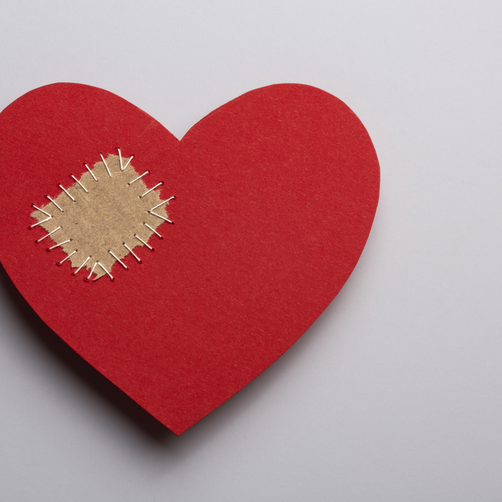 Большое красное сердце с заплаткой на сером фоне