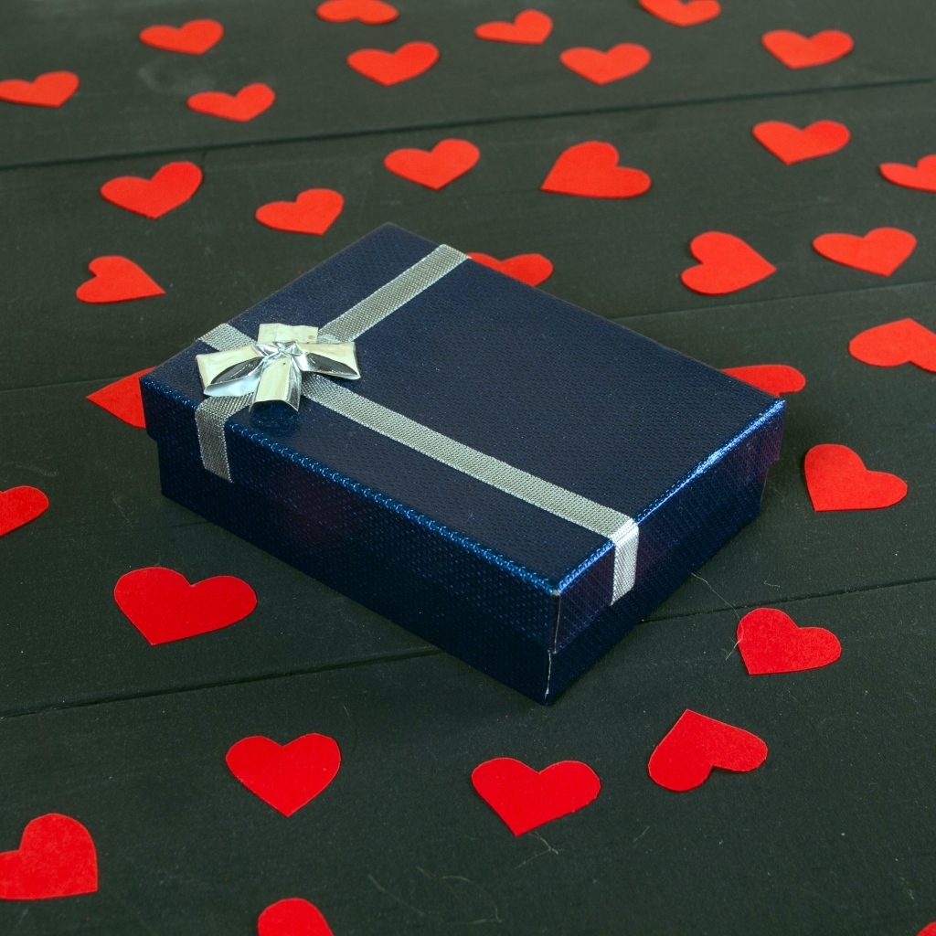 Черная коробка с красными сердечками на столе