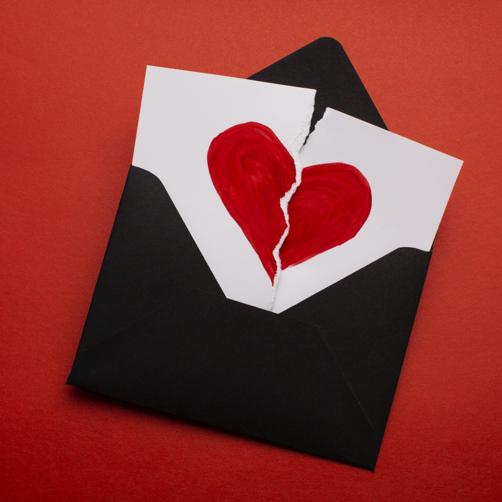 Черный конверт с нарисованным разбитым сердцем
