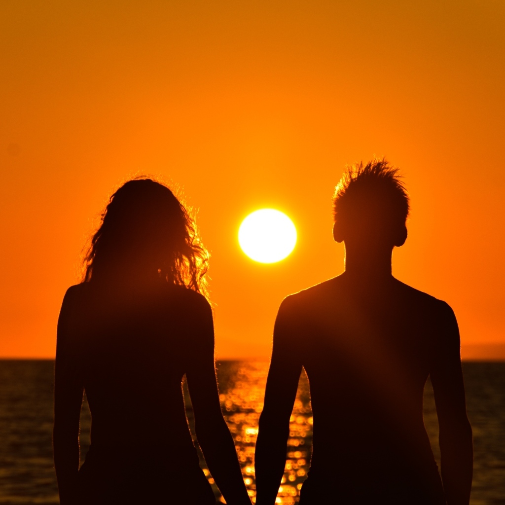 Влюбленная пара на фоне заката у моря