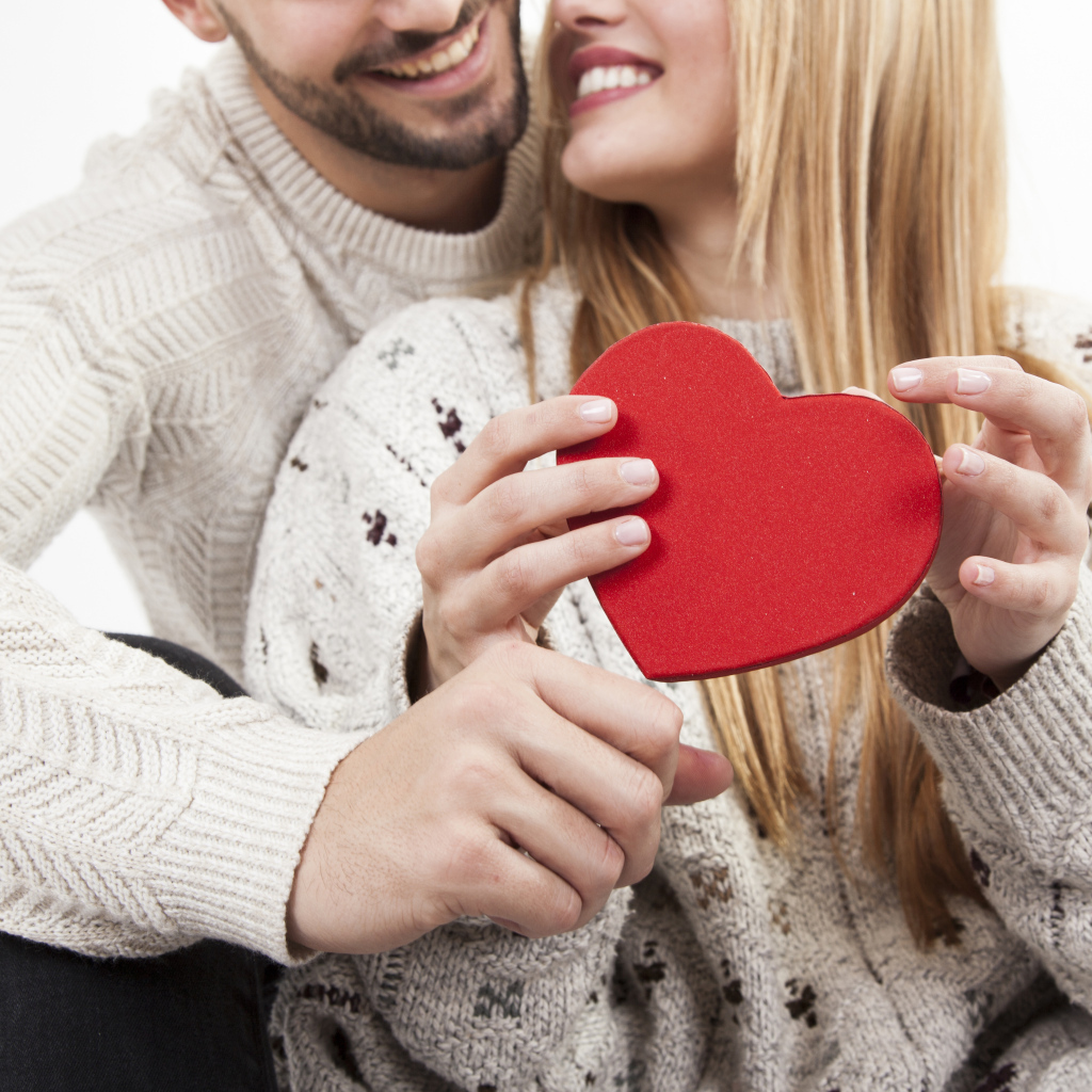 Влюбленная пара с красным сердцем в руках