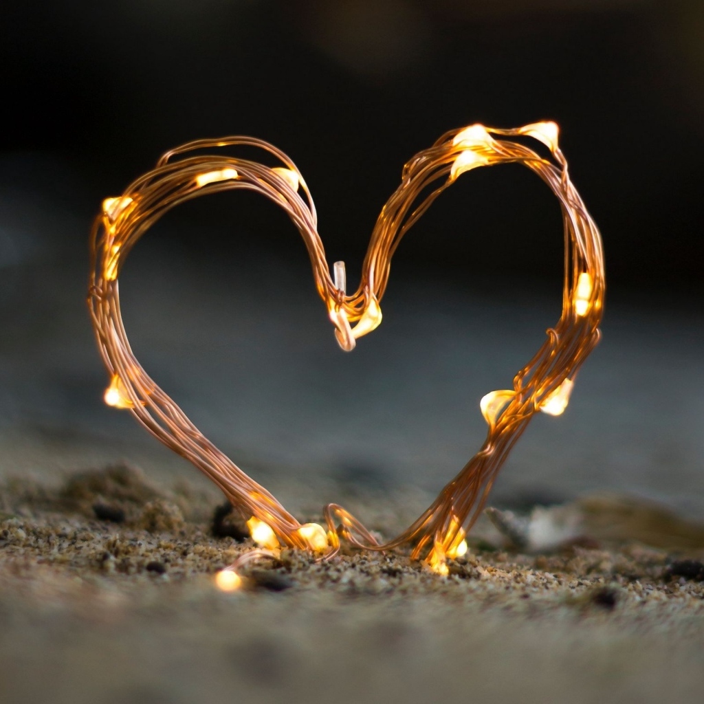 Сердце из гирлянды на песке