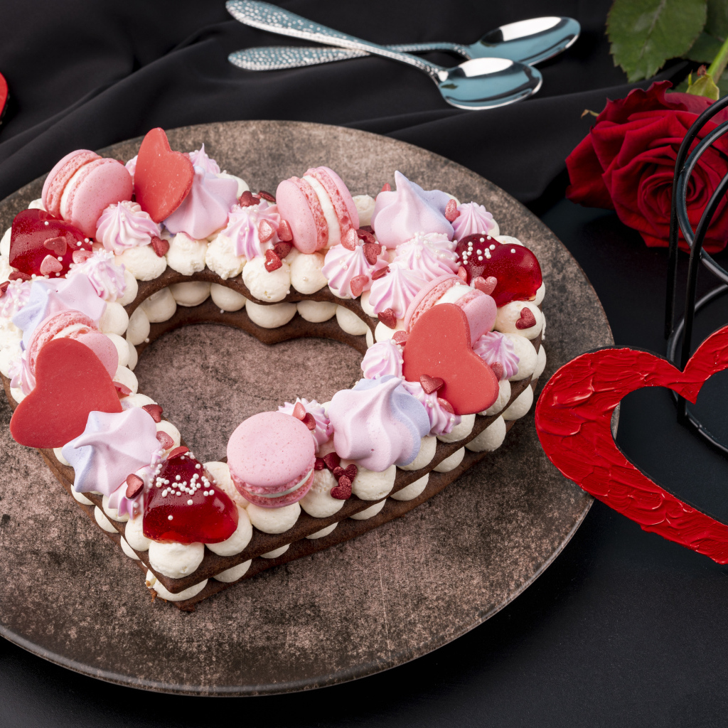 Десерт в форме сердца на столе с красной розой