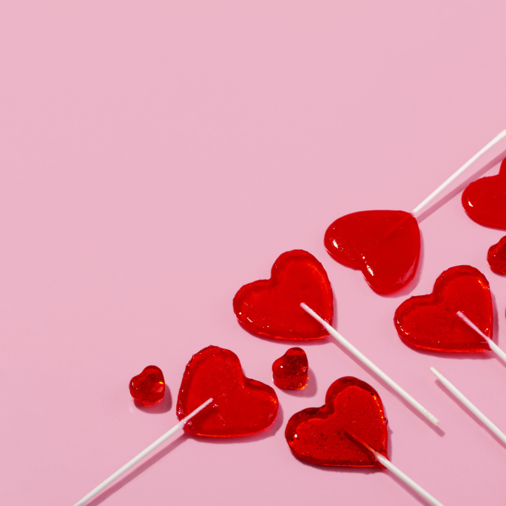 Леденцы в форме сердца на розовом фоне