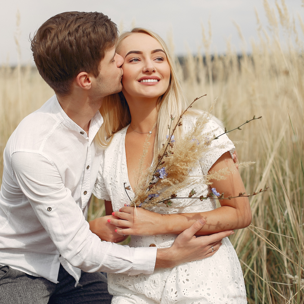 Поцелуй красивой пары на поле