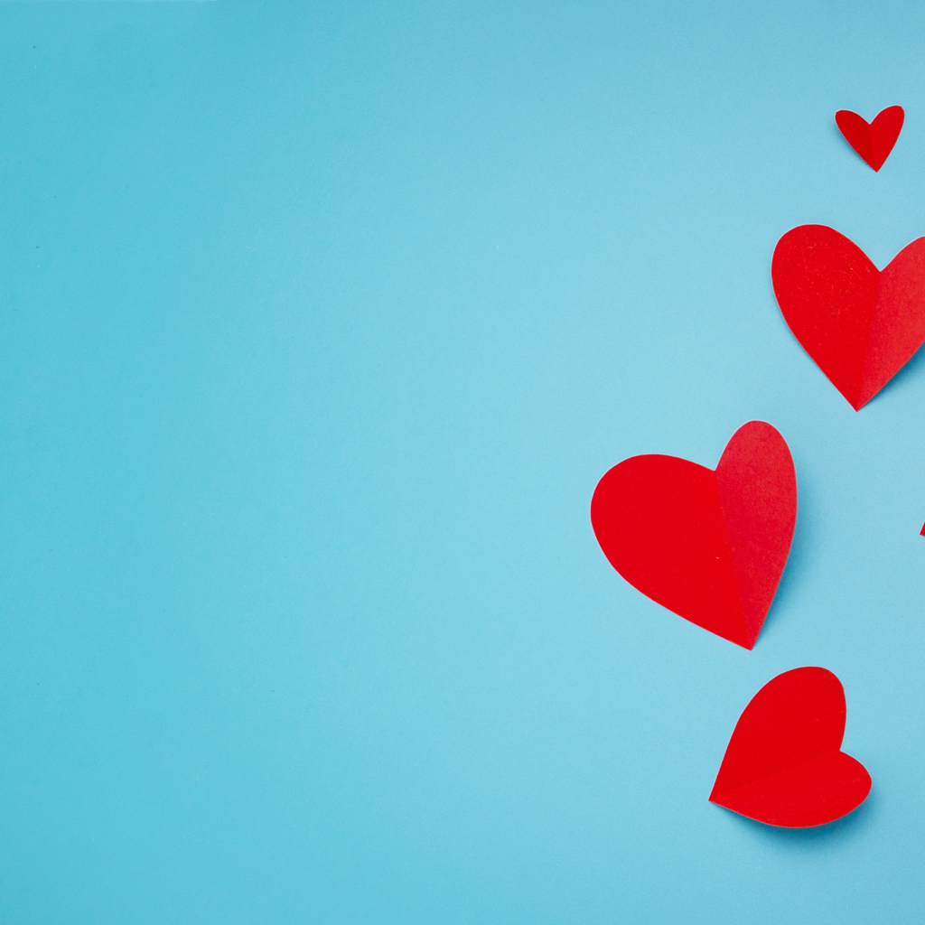 Много красных бумажных сердечек на голубом фоне