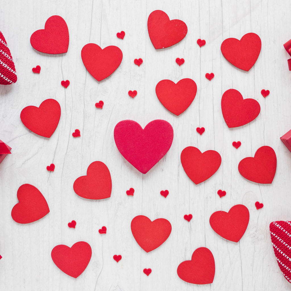 Много красных сердечек с подарками на белом фоне