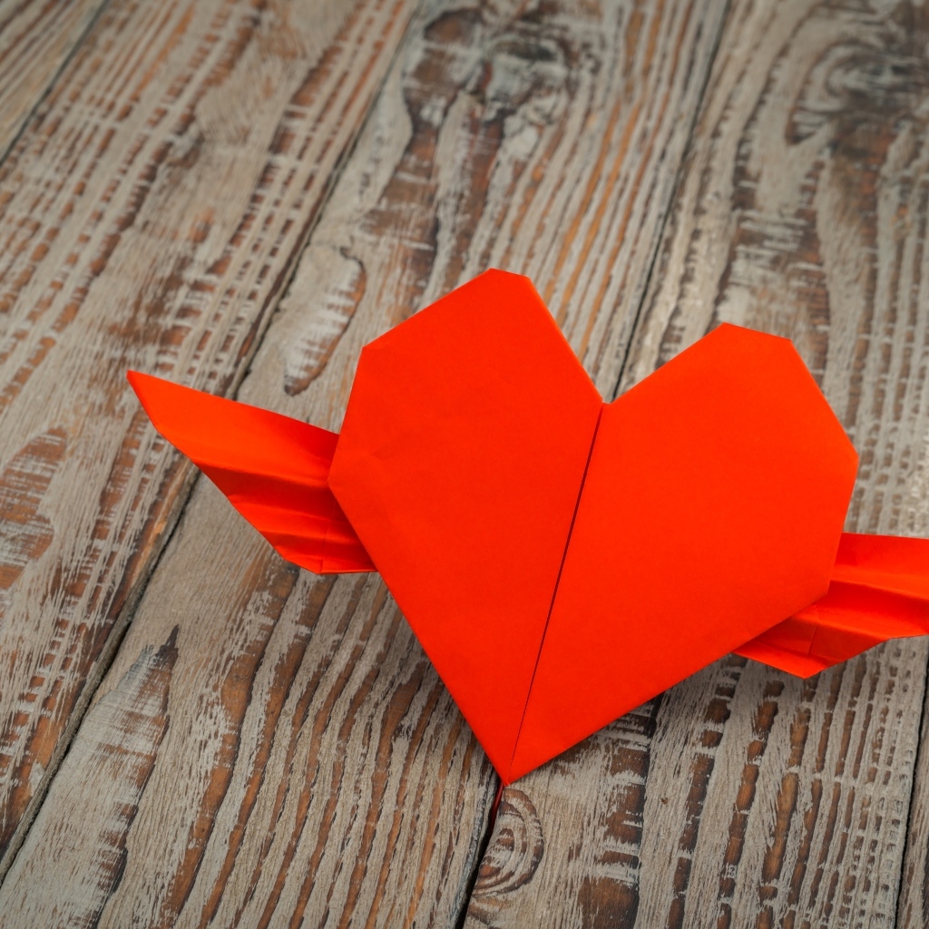 Бумажное красное сердце на деревянных досках