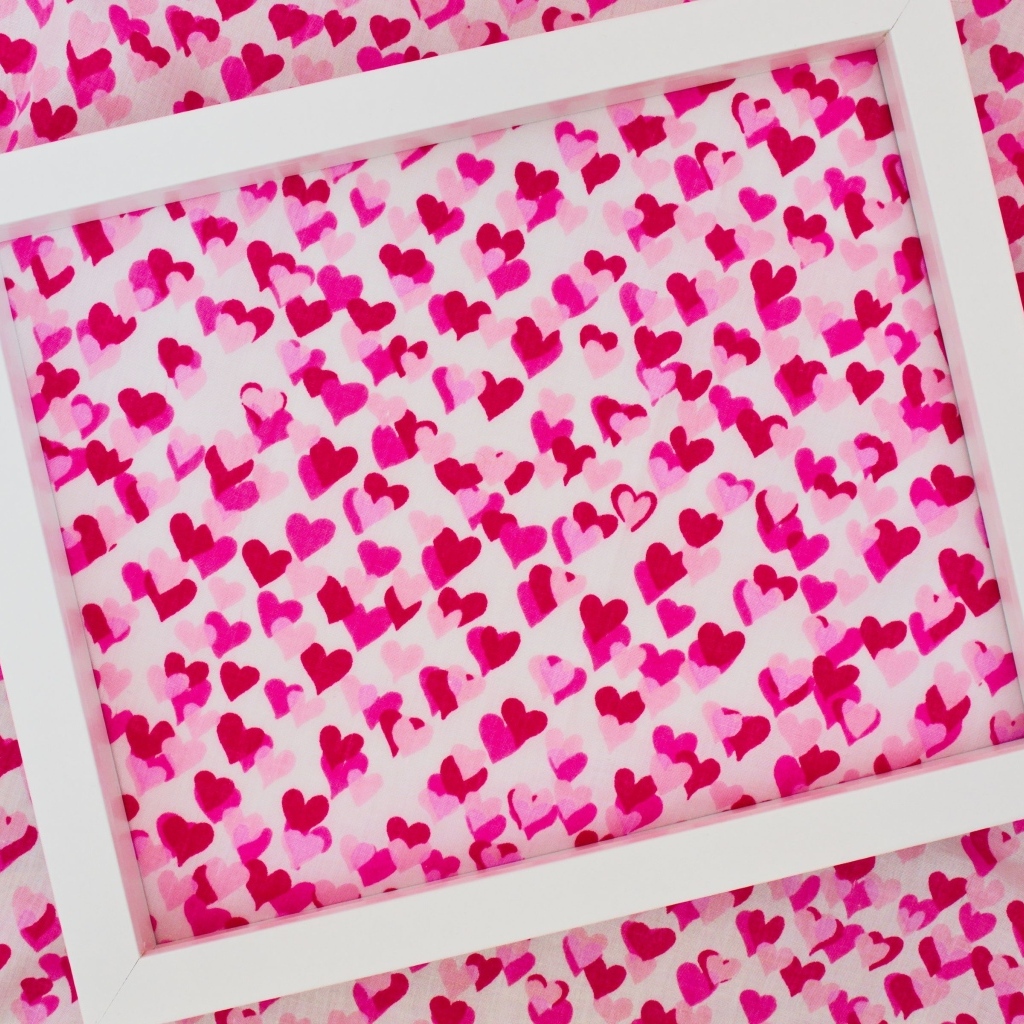 Белая рамка на ткани с маленькими сердечками