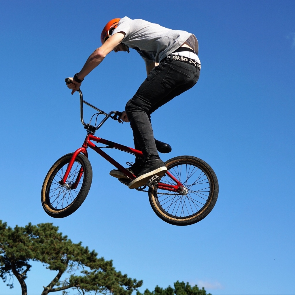 Мужчина делает прыжок на велосипеде на фоне неба