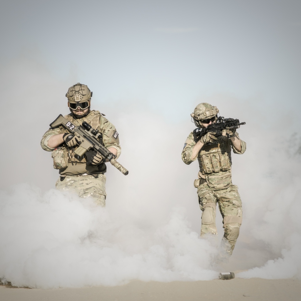 Мужчины солдаты с оружием в дыму