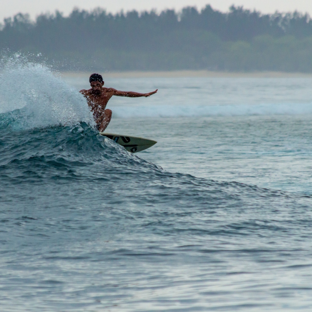 Мужчина серфингист ловит волну