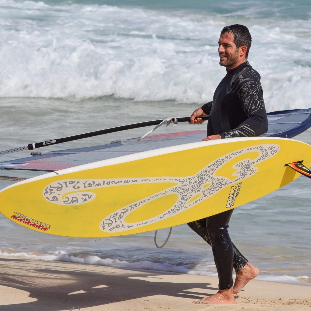 Мужчина серфер с доской на пляже