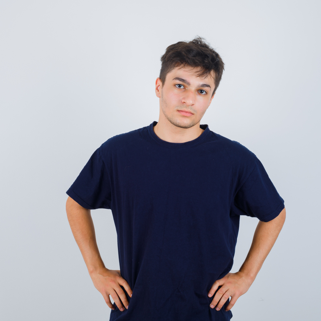 Молодой парень в синей футболке на сером фоне