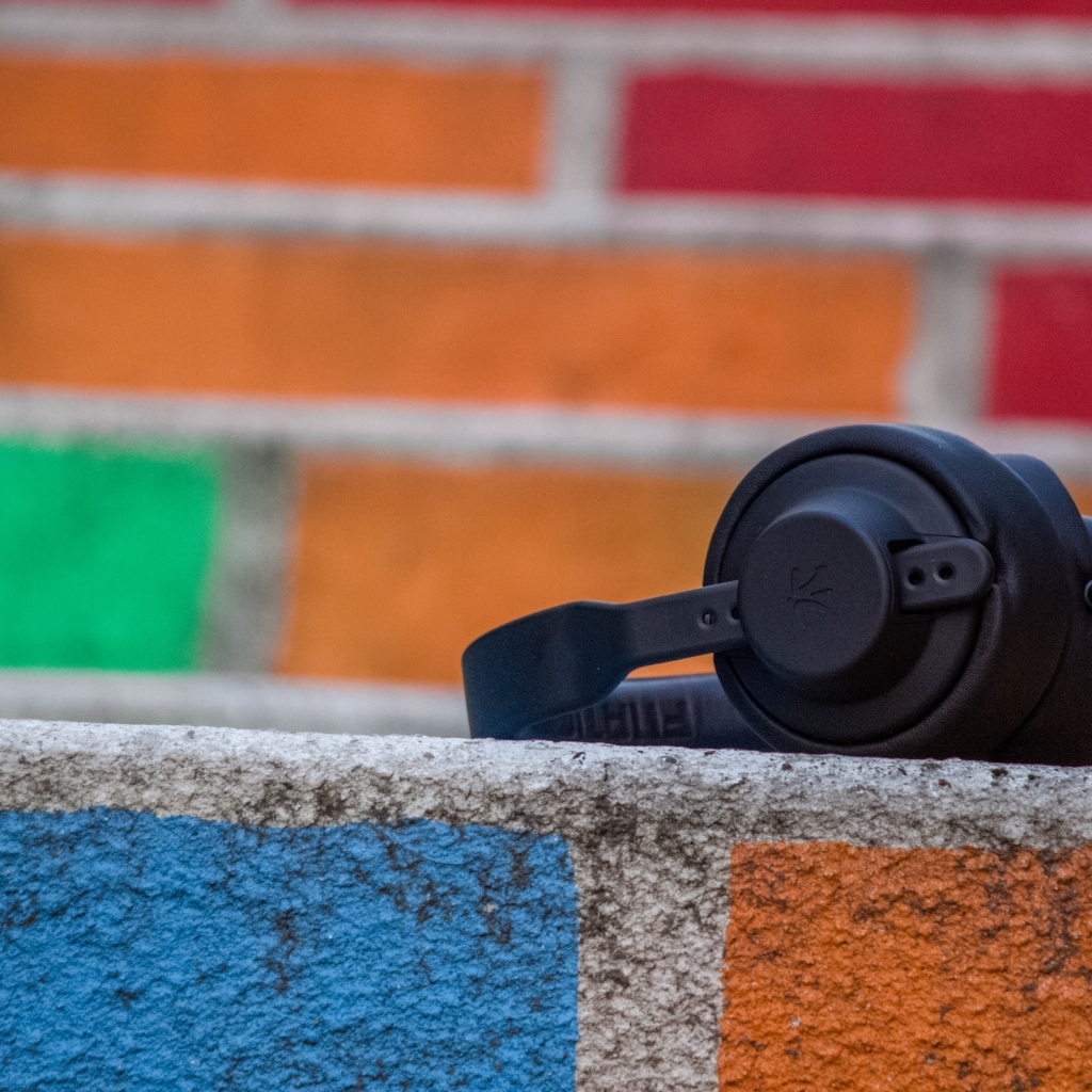 Черные наушники лежат на стене