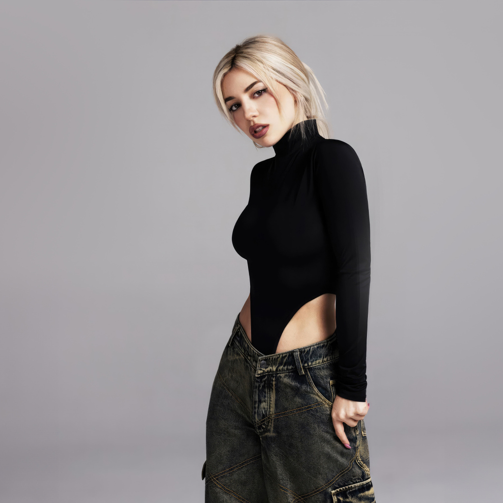 Милая блондинка певица  Эйва Макс на сером фоне