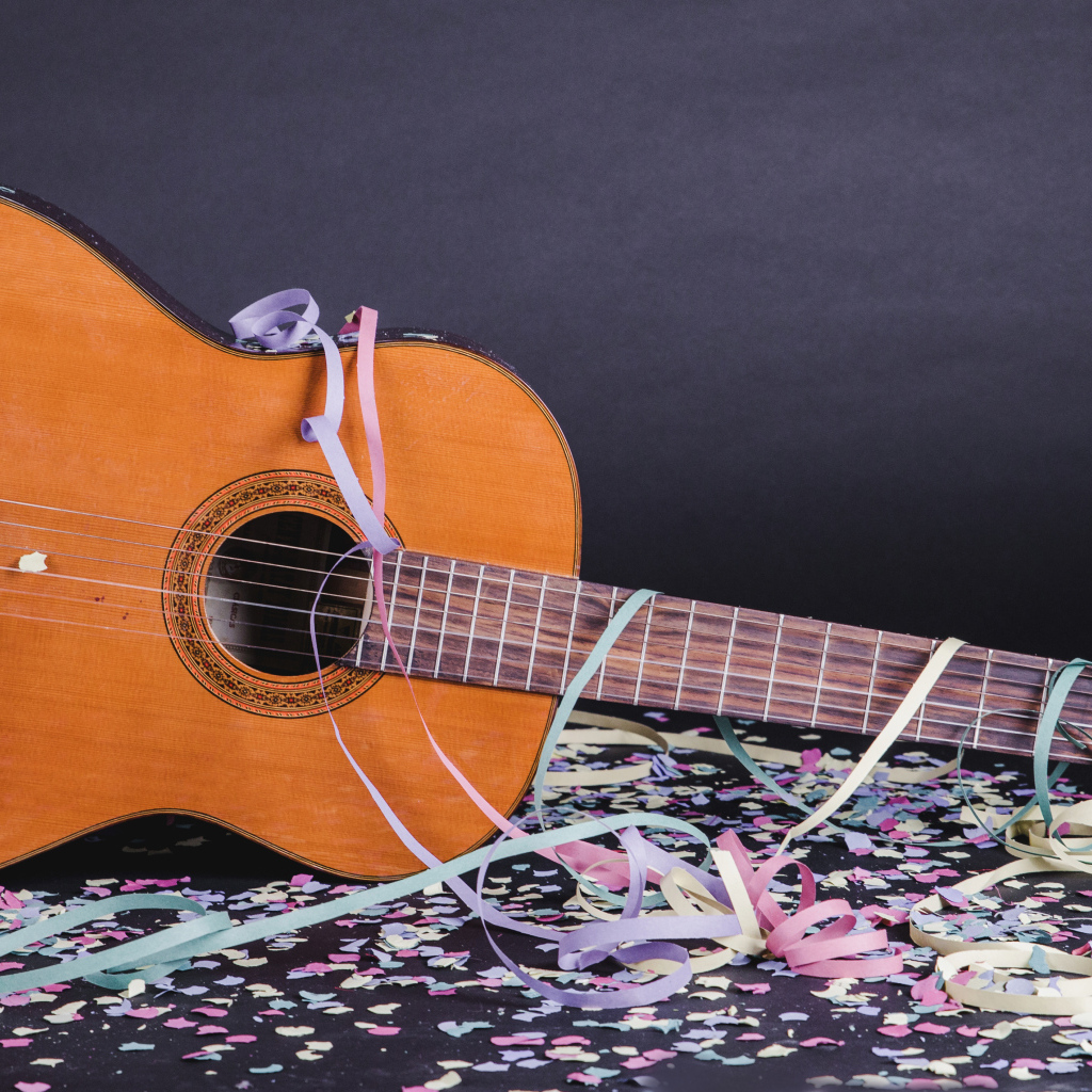 Гитара в конфетти у серой стены