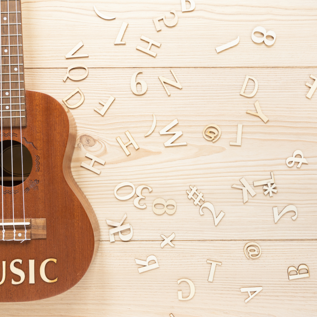 Гитара на столе с деревянными буквами