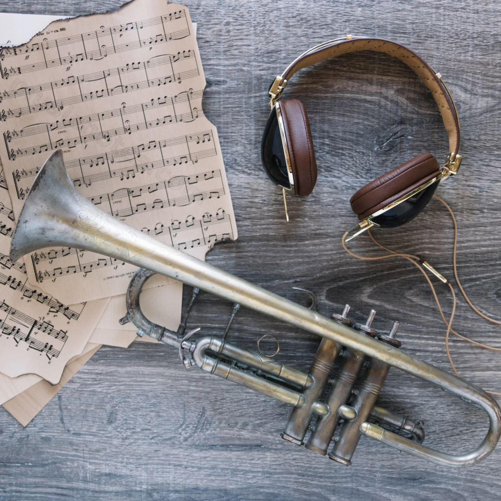 Старые ноты, наушники и труба на столе