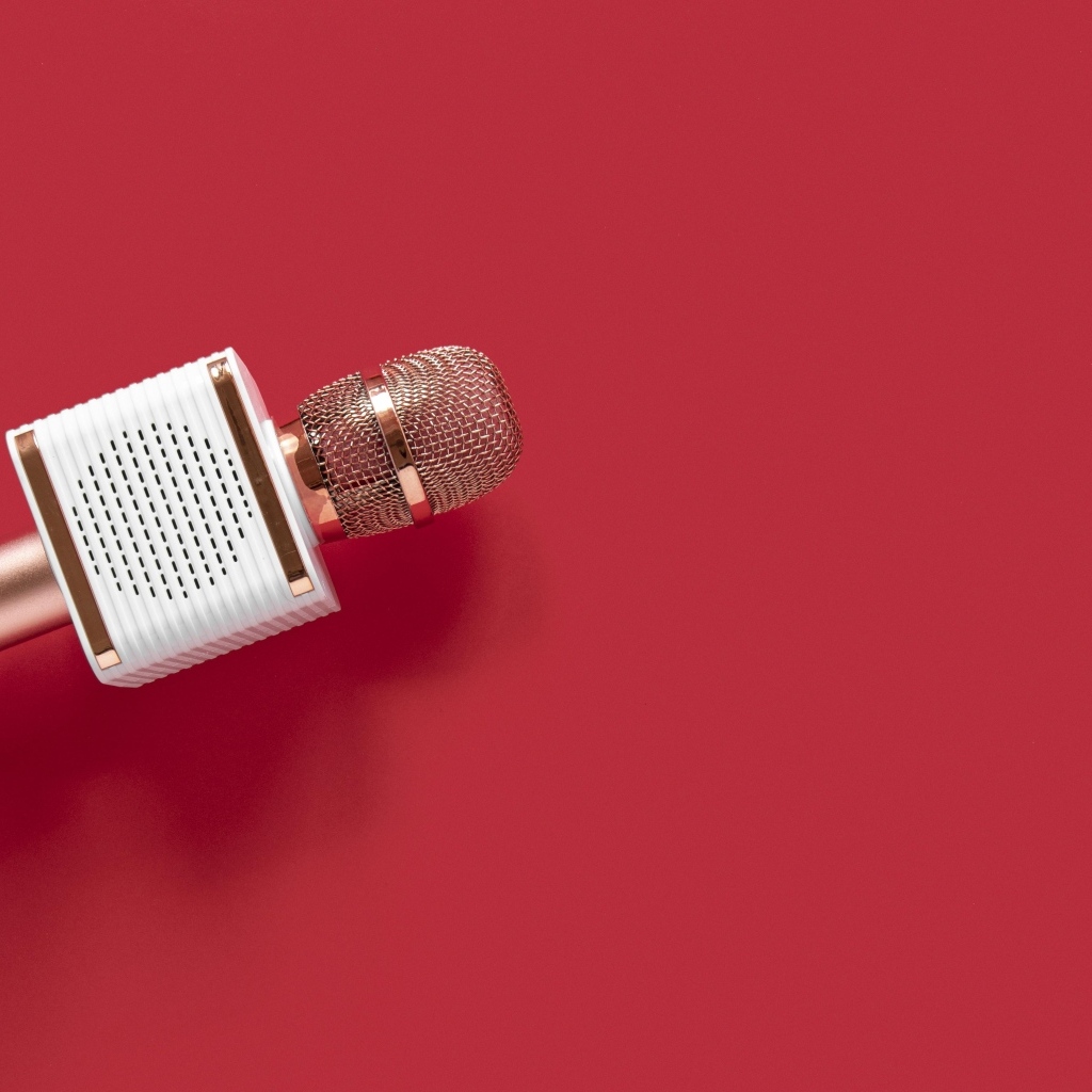 Радиомикрофон в руке на красном фоне