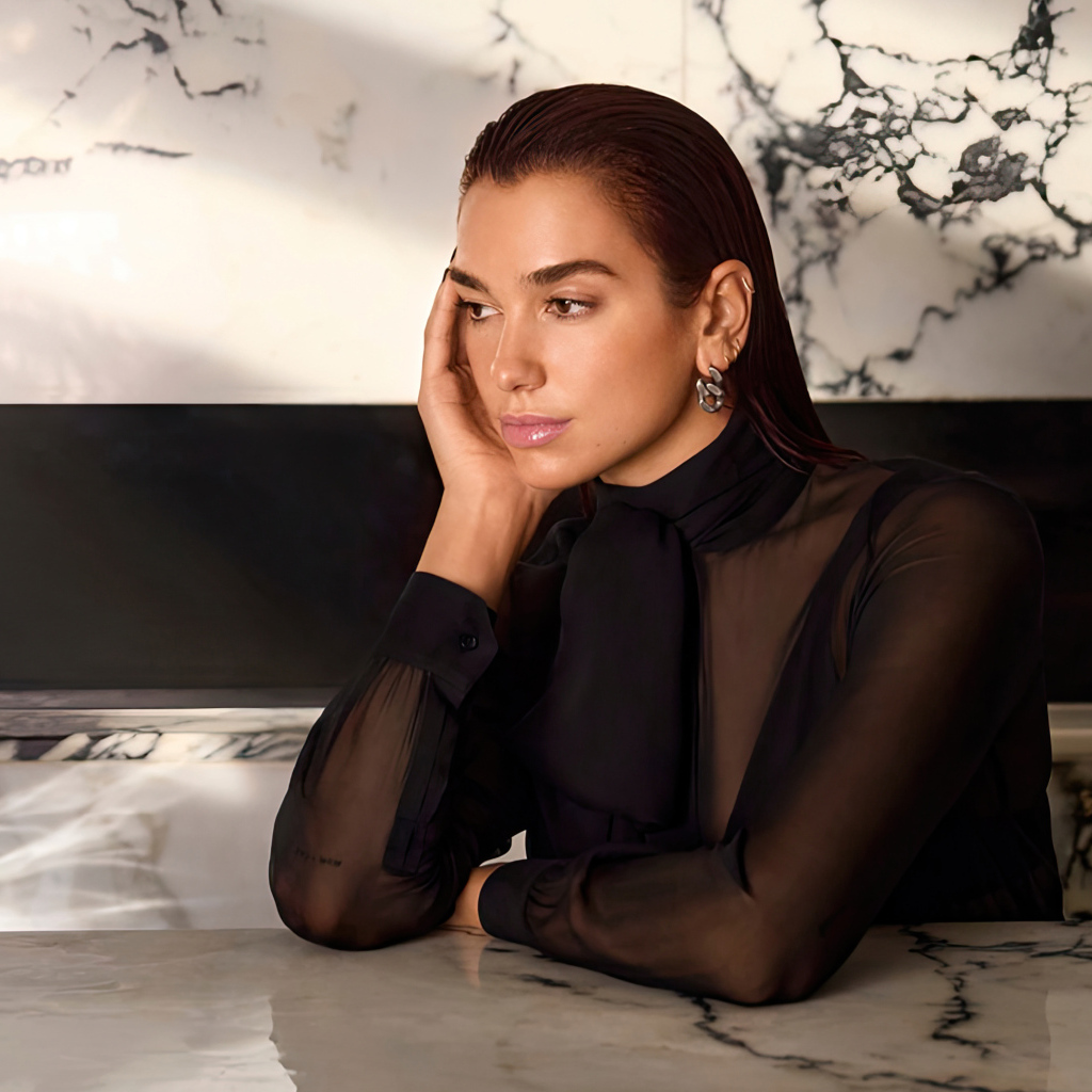 Грустная певица Дуа Липа сидит за столом