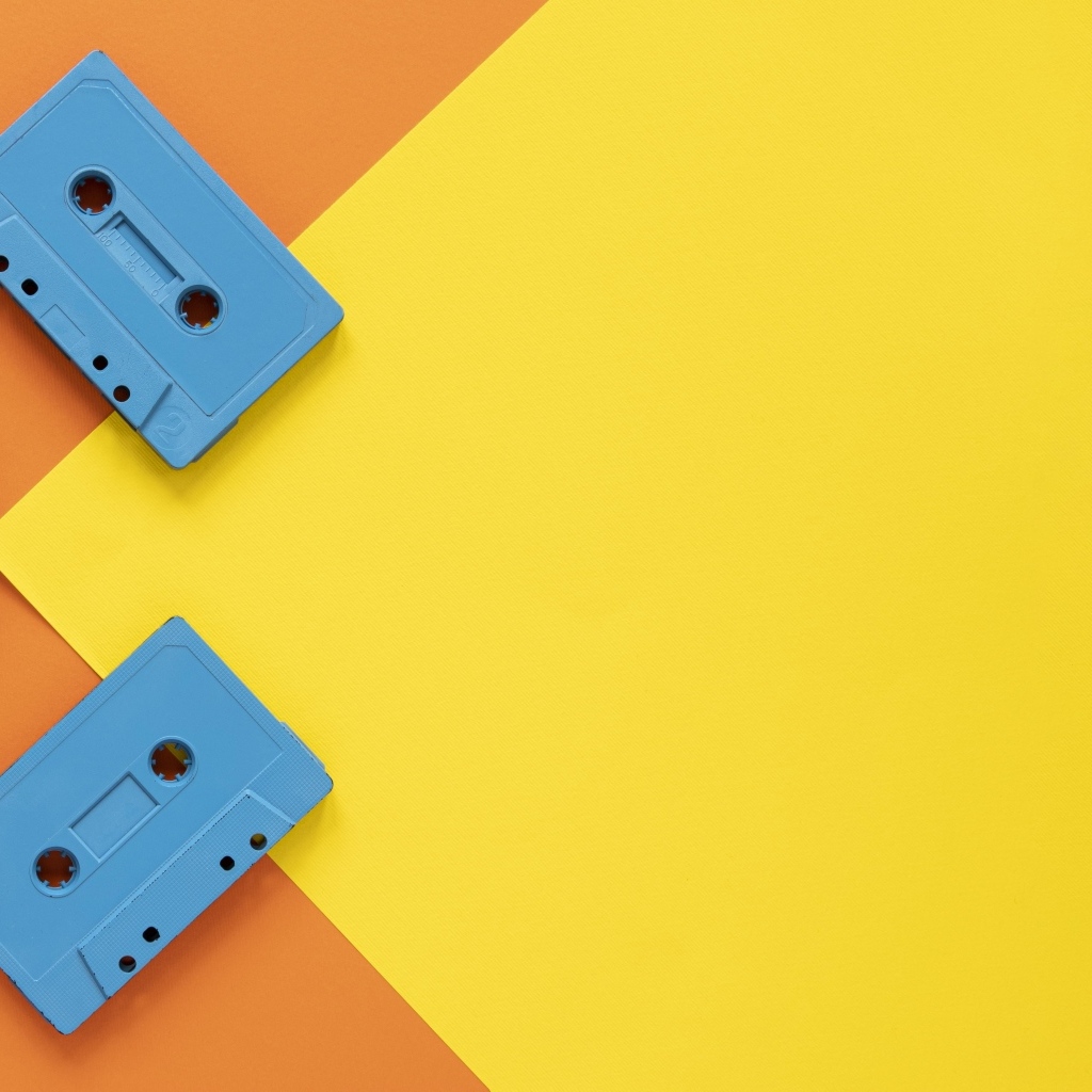 Три голубые кассеты на желто-оранжевом фоне
