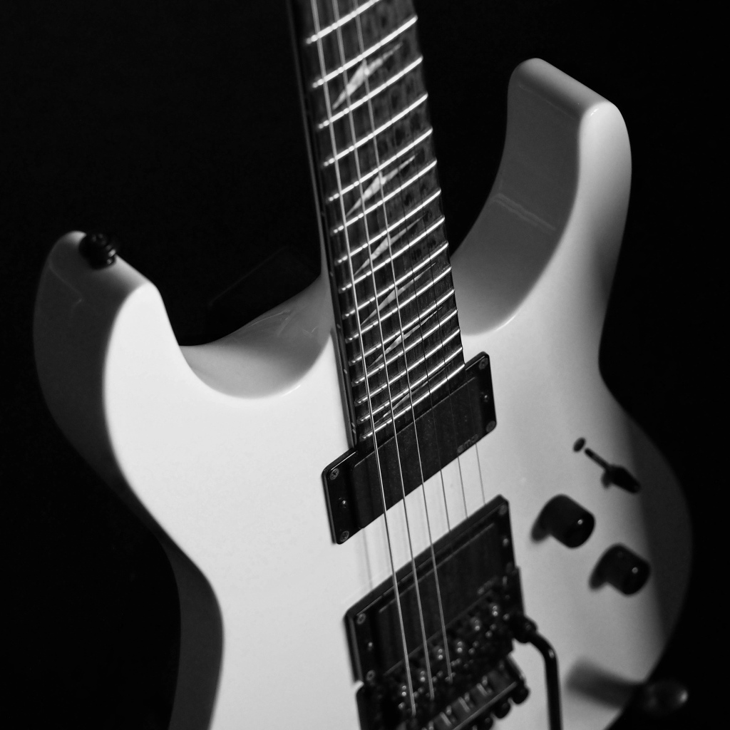 Белая электрогитара на черном фоне