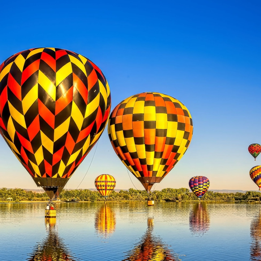 Большие воздушные шары над водой на фоне голубого неба