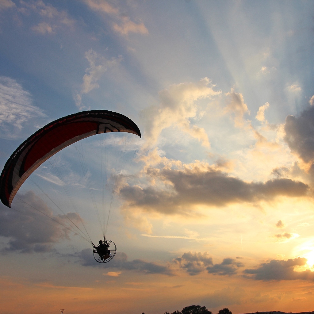 Параплан в небе на фоне солнца