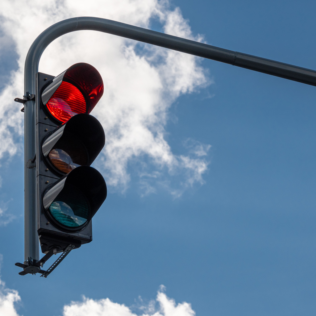 Красный свет светофора на фоне неба
