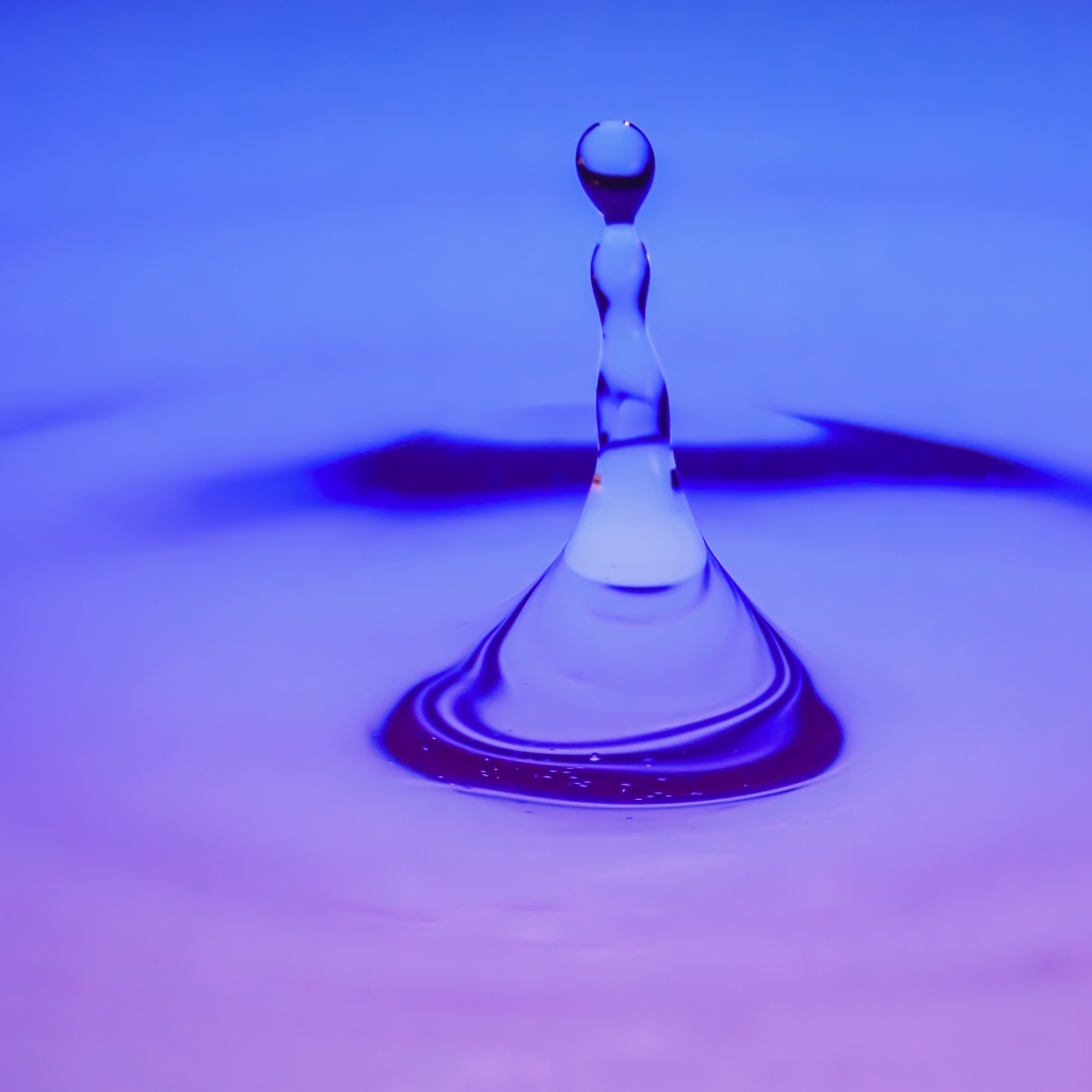 Брызги в воде на фиолетовом фоне