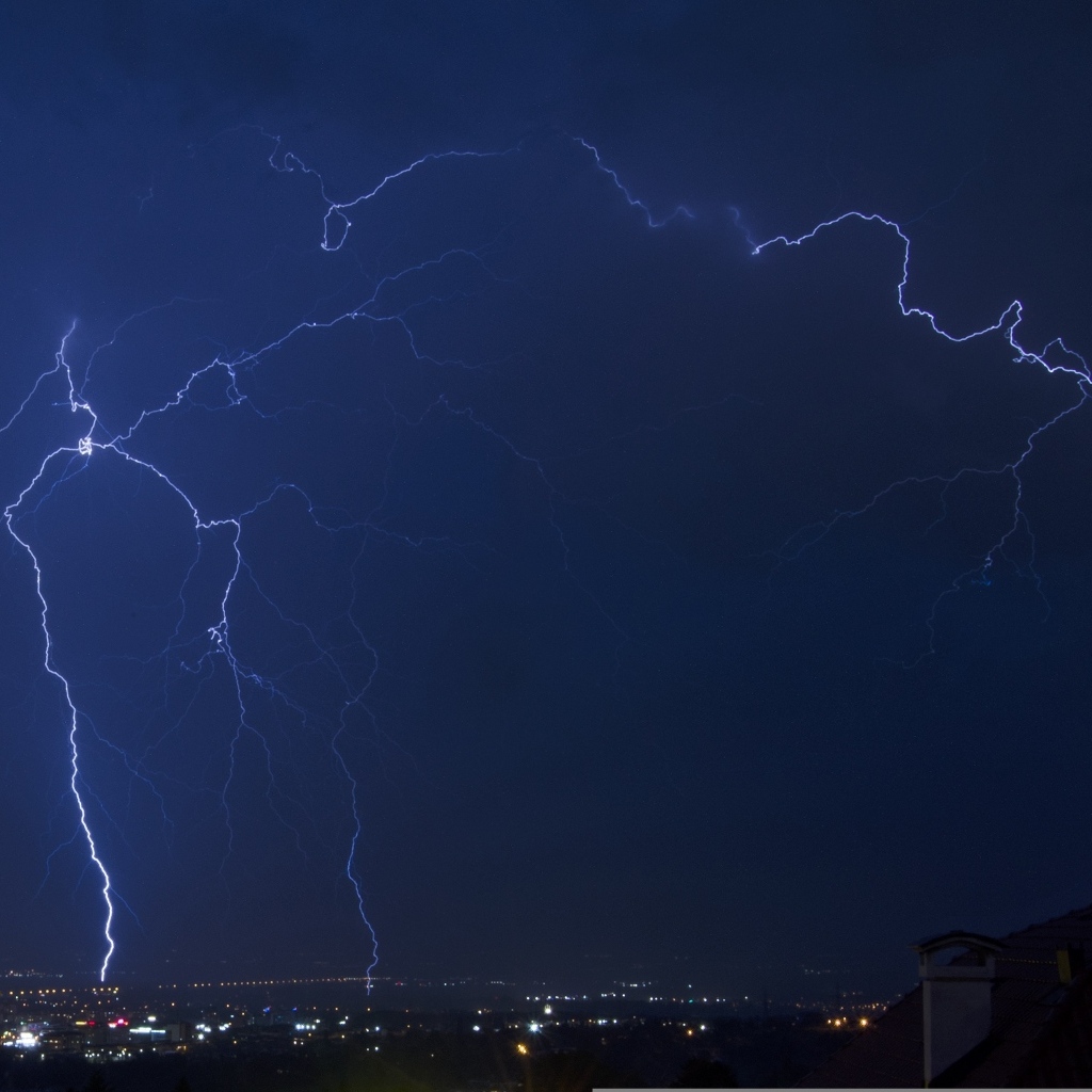 Белая яркая молния в небе над городом