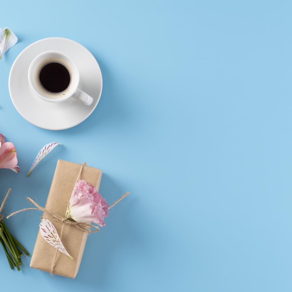 Букет цветов альстромерии с  подарком и чашкой кофе на голубом фоне