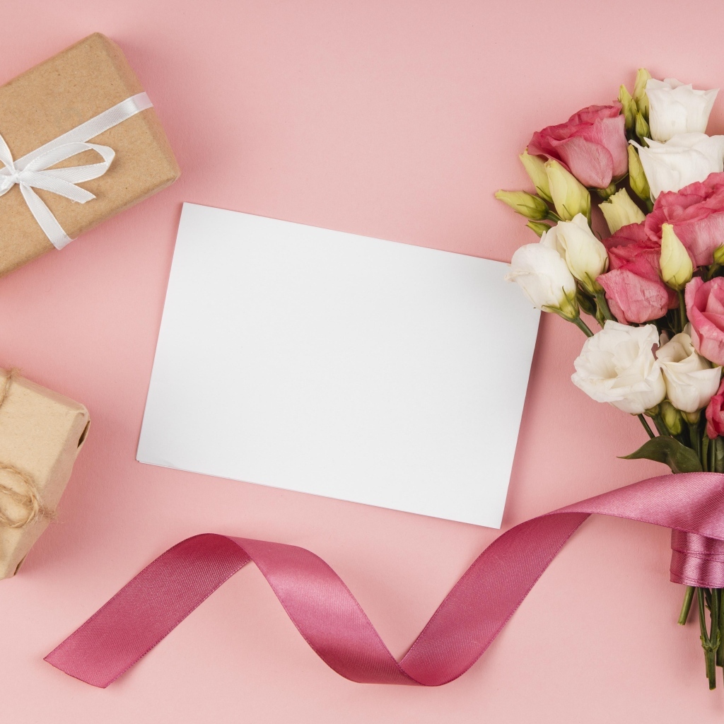 Букет эустомы с лентой на розовом фоне с подарками и белым листом
