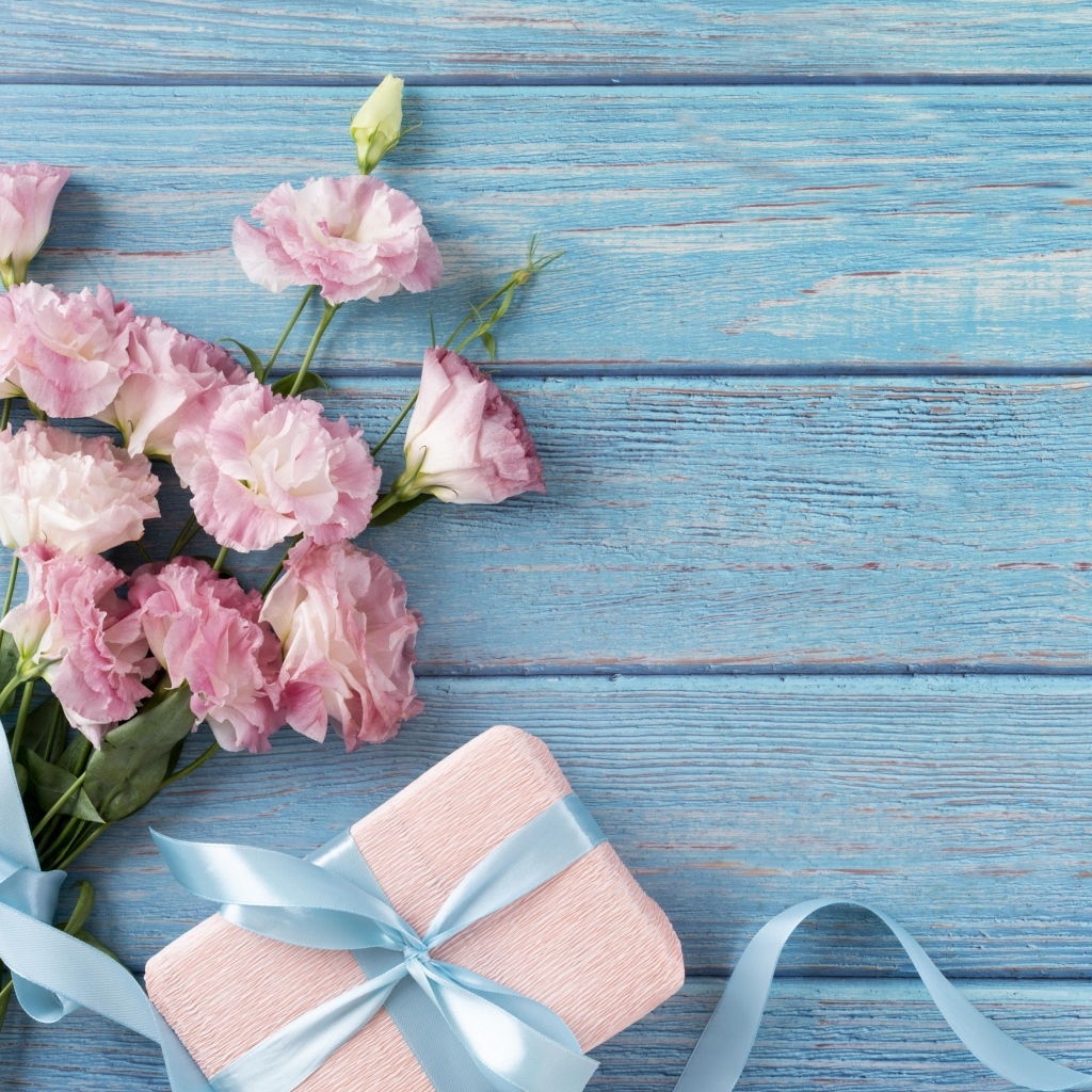 Букет розовой эустомы с подарком на голубом фоне