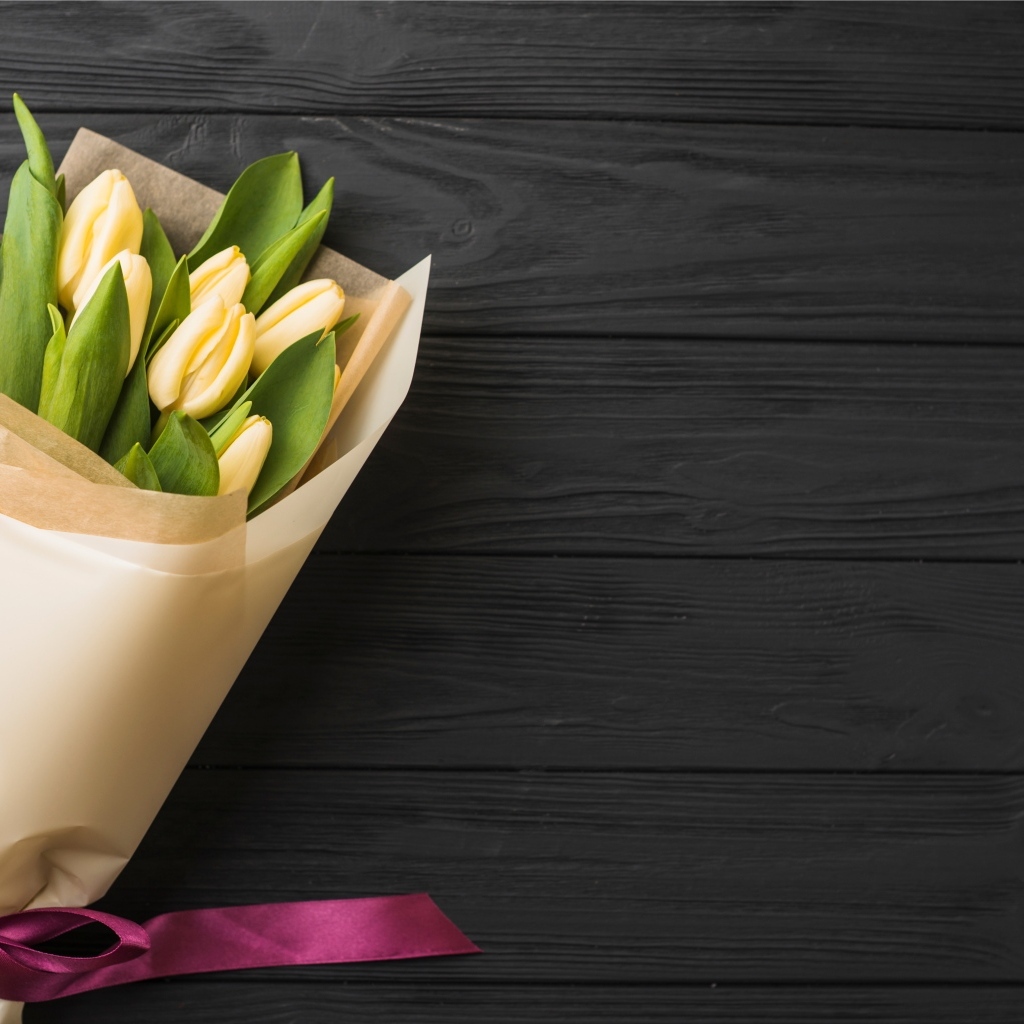 Букет желтых тюльпанов в бумажной упаковке с лентой