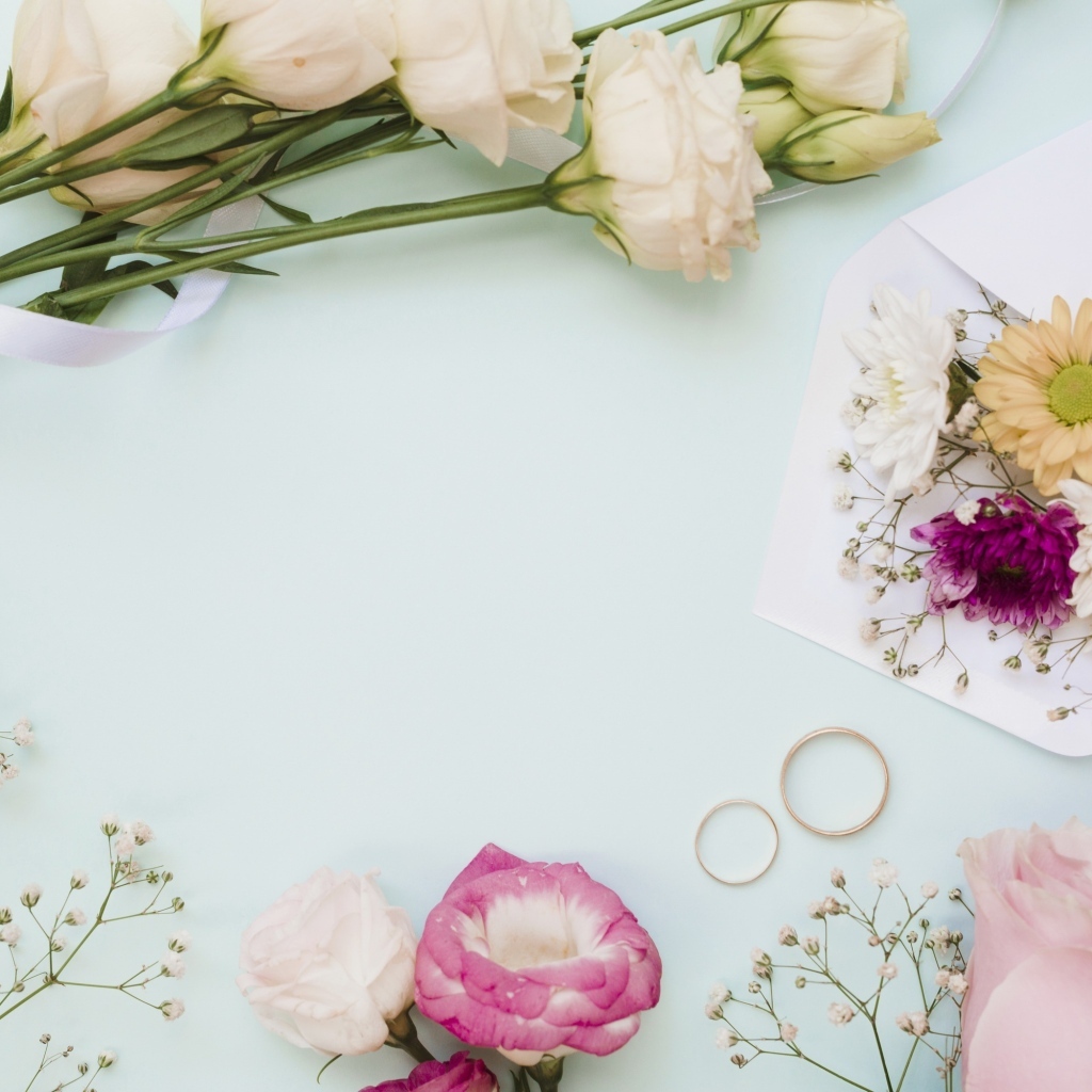 Цветы на голубом фоне с конвертом и обручальными кольцами