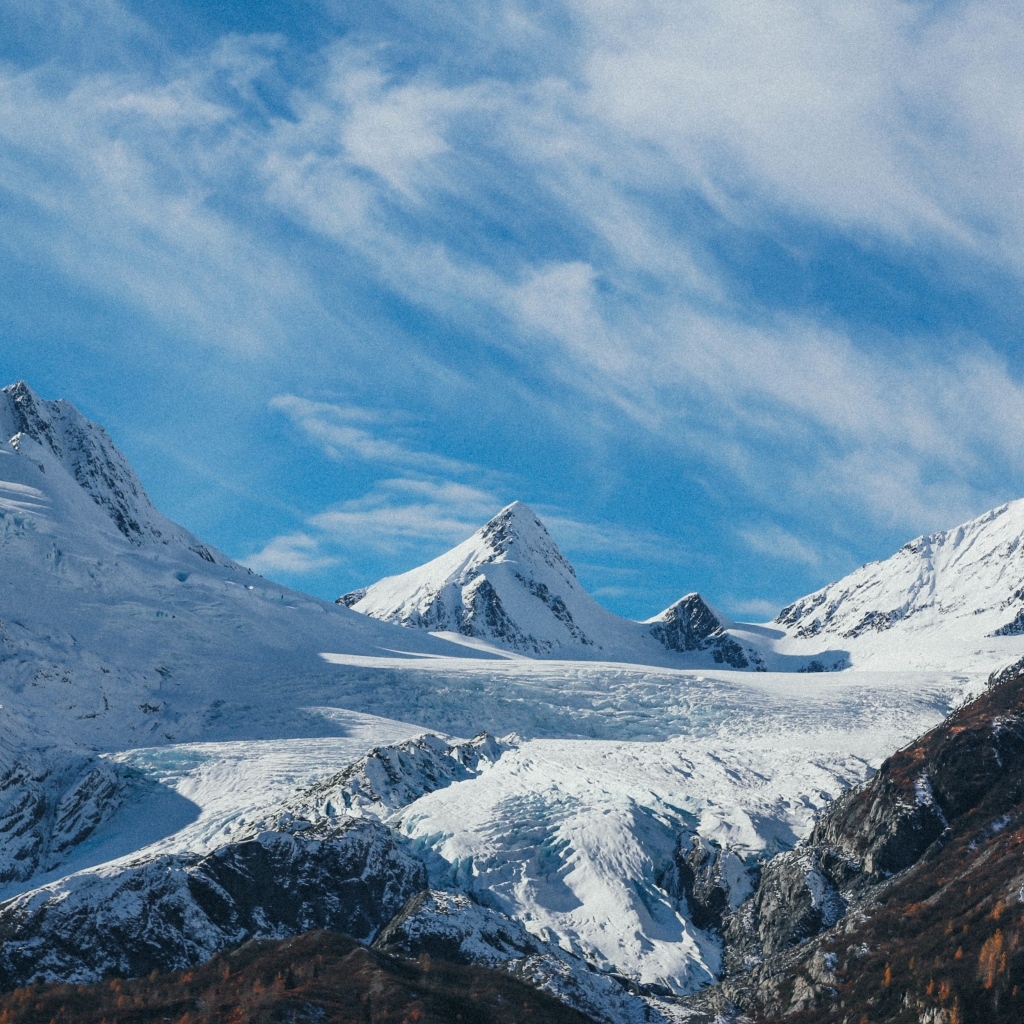 Высокие заснеженные горы под голубым ясным небом