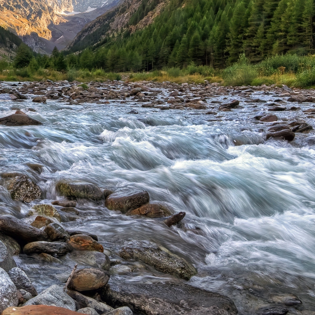 Быстрая холодная река стекает по камням в горах 