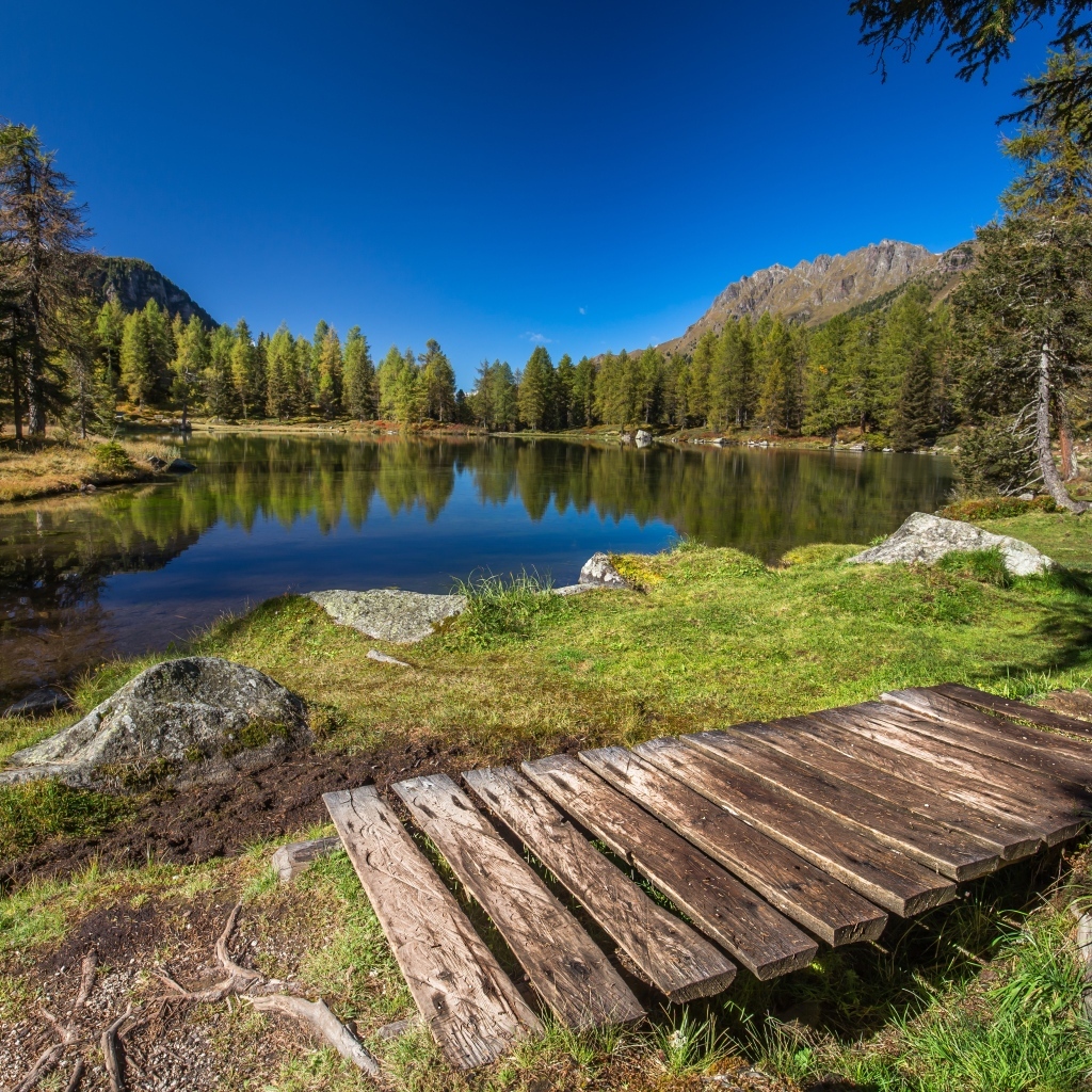 Мост на берегу озера в горах под голубым небом