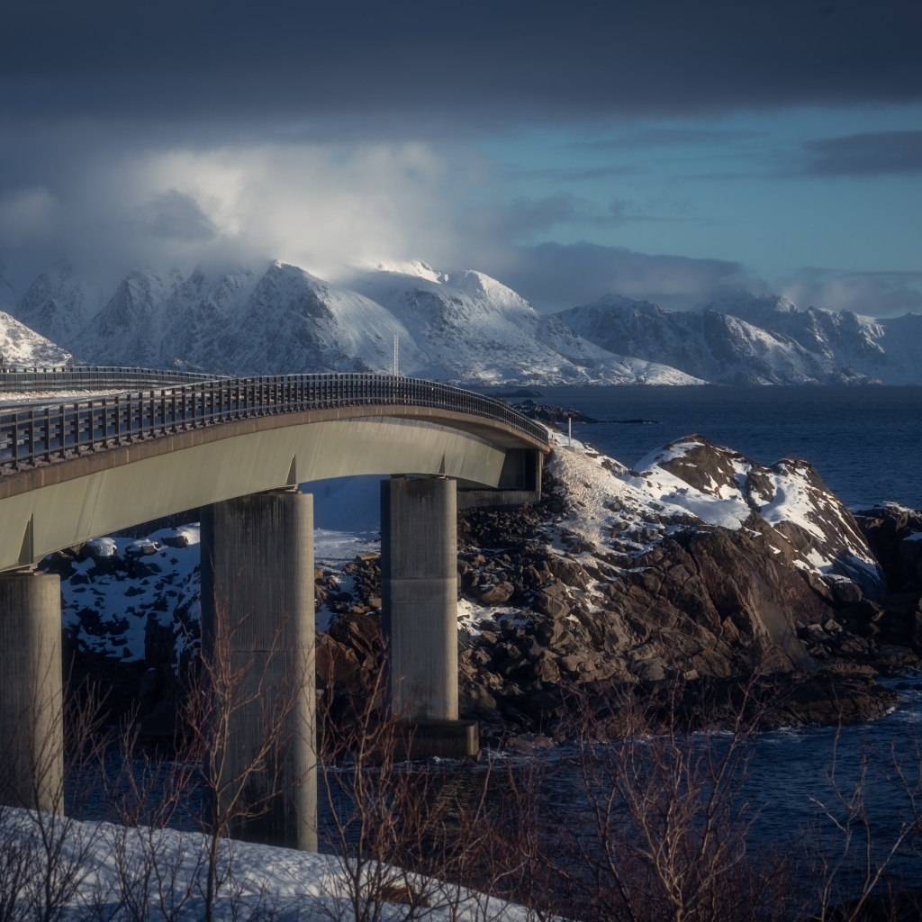 Мост через реку в заснеженных горах 