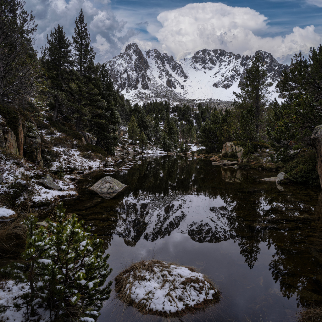 Холодная вода в озере с большими камнями на фоне гор