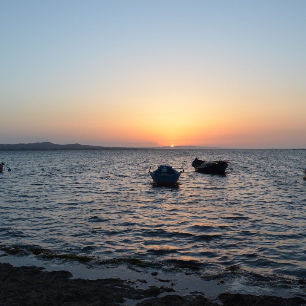 Лодки на морском побережье на закате