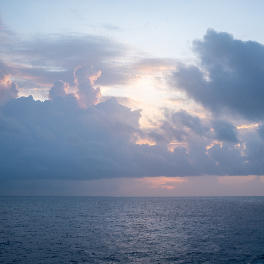 Густые белые облака над морем на рассвете летом