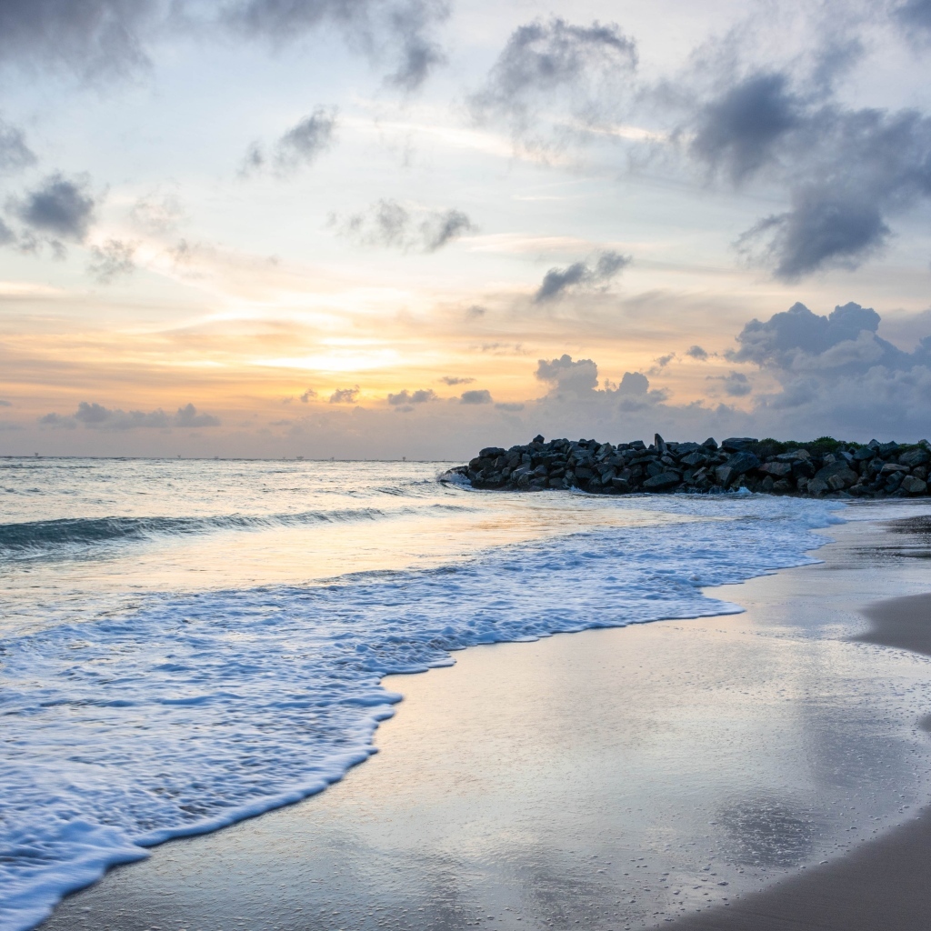 Волны омывают морской песок на рассвете