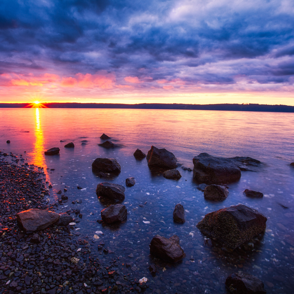 Закат солнца в пасмурном небе у озера