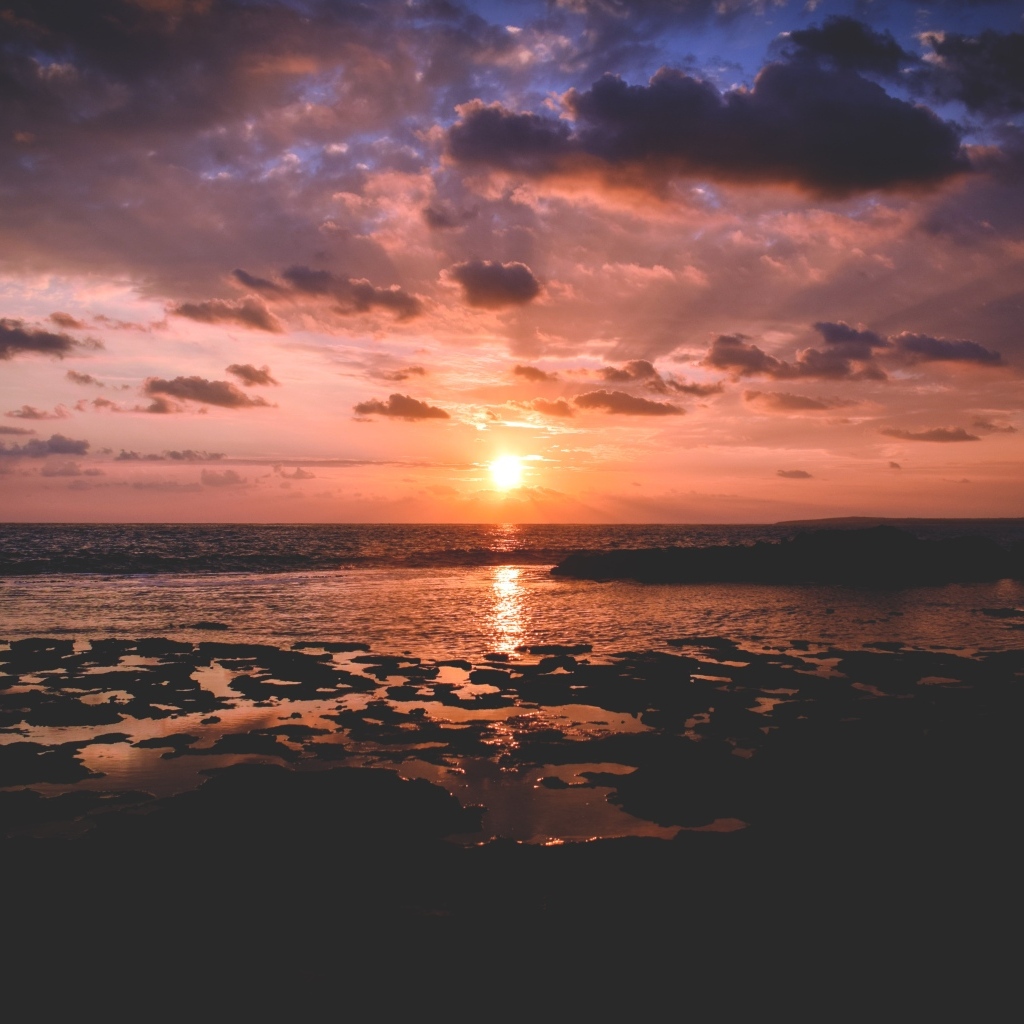 Закат яркого летнего солнца в небе над морем