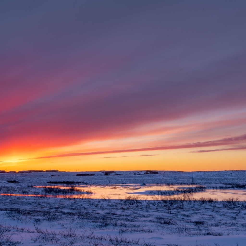 Закат солнца над покрытым снегом полем Аляски