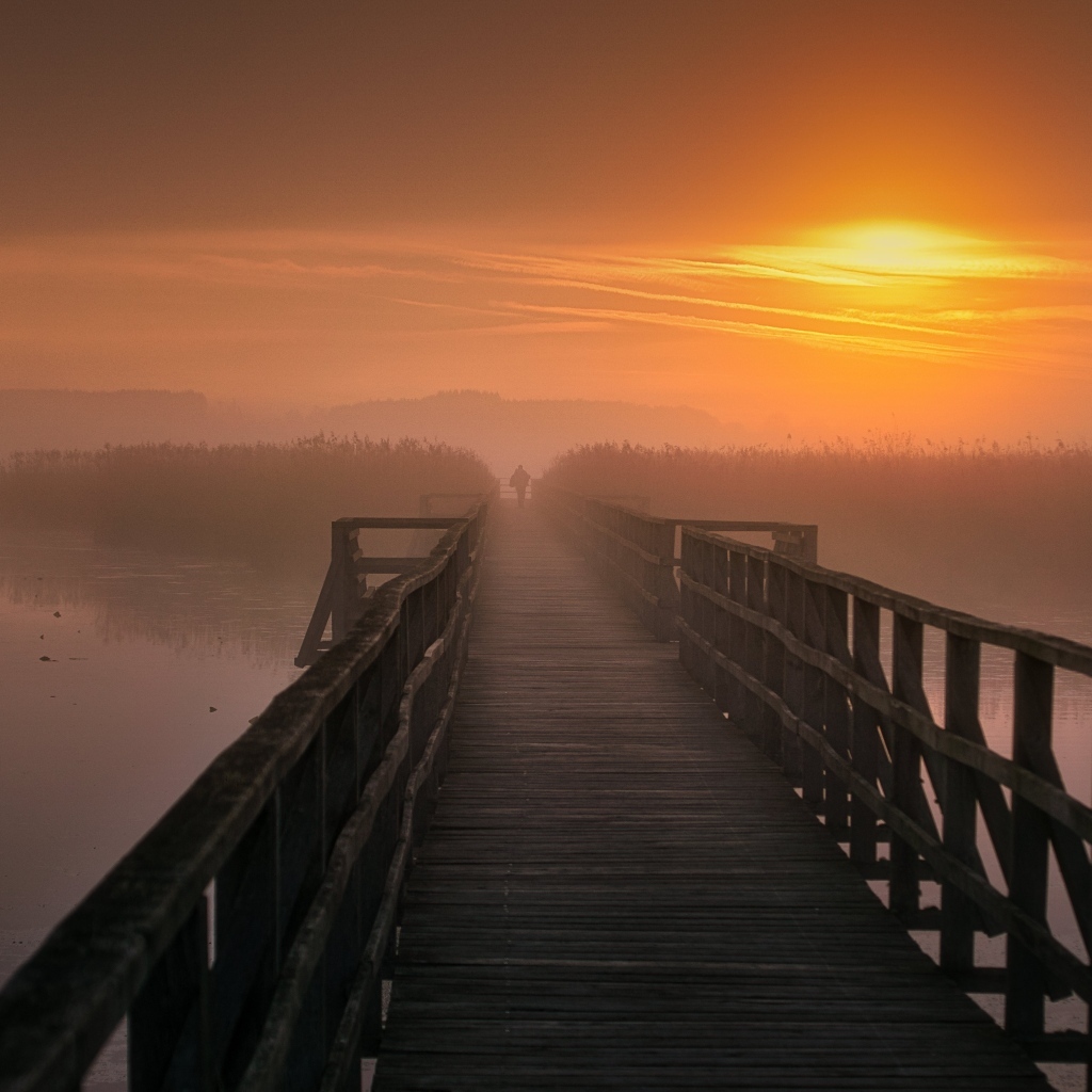 Деревянный мост над рекой на закате