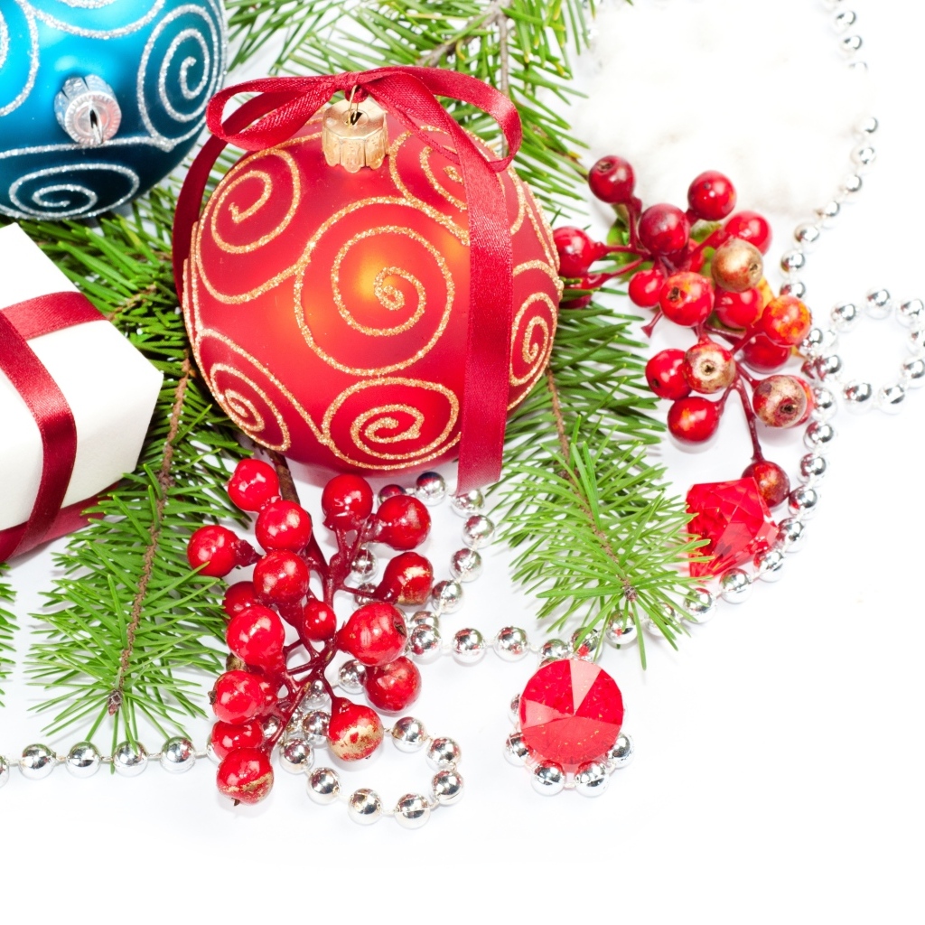 Разноцветные елочные игрушки с ветками на белом фоне